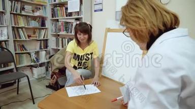 心理学家办公室里的一个十几岁`女孩靠纸画。 心理测试。